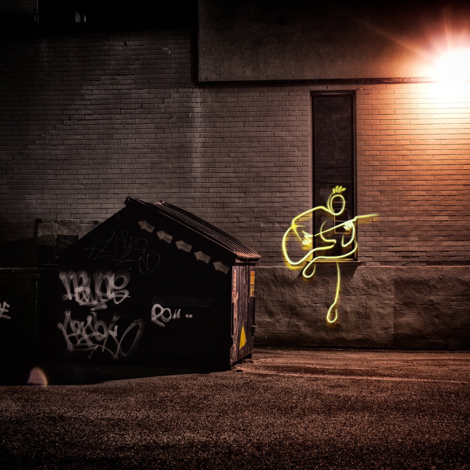 Guitarrista desenhado em luz neon amarela diante de um muro de tijolos